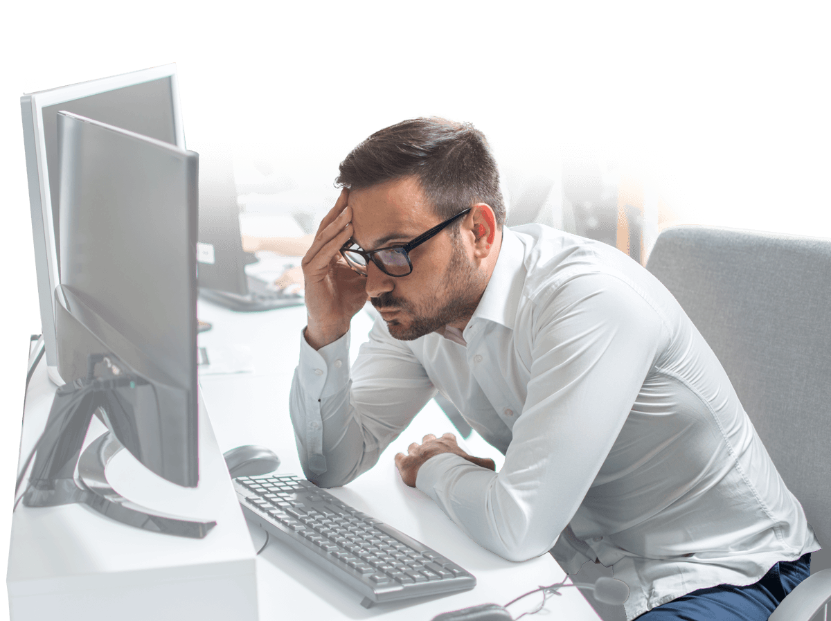Frustrated man holding head while looking at computer screen